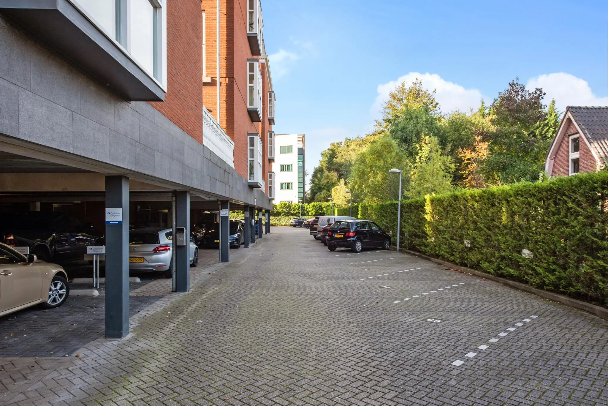 Parkeerterrein met deels overdekte parkeerplaatsen bij een appartementencomplex aan de Laan van Vredenoord.